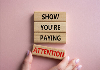 Attention symbol. Concept word Show You are Paying Attention on wooden blocks. Beautiful pink background. Businessman hand. Business and Show You are Paying Attention concept. Copy space