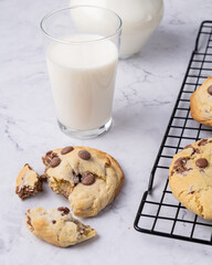 Chocolate chip cookies over marble table with milk
