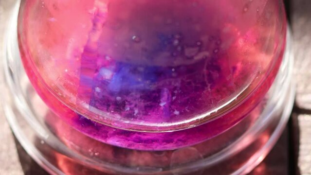 The beginning of the colorful chemical reaction of the formation of an insoluble solid substance cobalt silicate of violet color in sunlight.