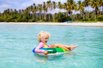 Child on tropical beach. Sea vacation with kids.