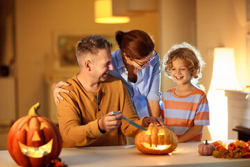 Family carving pumpkin. Halloween trick or treat