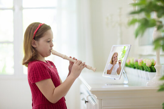 Child playing flute. Remote learning. - Powered by Adobe