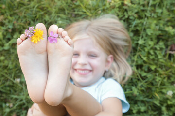 Child feet on green grass, barefoot little girl on meadow, countryside lifestyle, concept of...