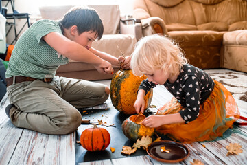Costume-clad kids enjoy carving pumpkins in preparation for a bewitching Halloween.