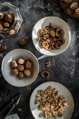 Walnut kernels and whole walnuts on dark stone table