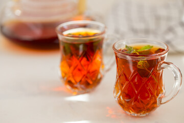 Red tea with mint in a transparent cup 