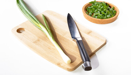 Healthy eating.Green onions on a kitchen board,knife and chopped greens