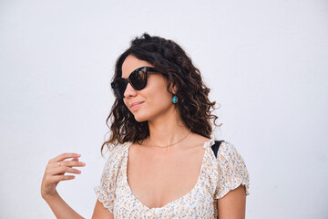 Stylish young girl: 26 year old brown-haired beauty posing in front of a white wall.