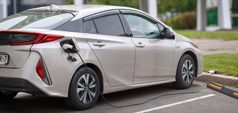 Minsk, Belarus. Aug 27, 2023. Toyota Prius Prime hybrid electric car charging battery at charge point. Toyota Prius Plug-in hybrid charging battery at free charging station. Side view