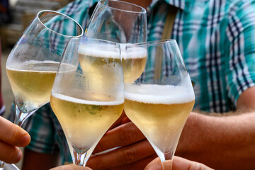 Tasting of sparkling white wine with bubbles champagne on summer festival route of champagne in Cote des Bar, Champagne region, France