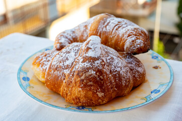 Italian sweet breakfast, fresh baked croissant buttery pastry with sugar powder