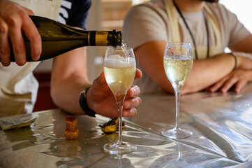 Tasting of sparkling white wine with bubbles champagne on summer festival route of champagne in Cote des Bar, Champagne region, France