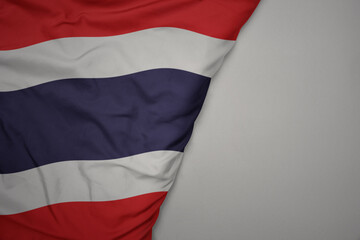 big waving national colorful flag of thailand on the gray background.