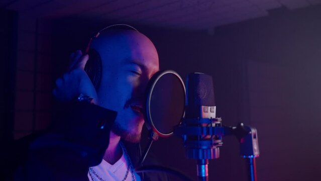 man is singing and recording single and new track for new musical album, portrait in isolation booth