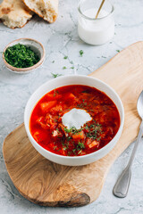 Traditional Russian and Ukrainian Borscht Meal with Bread, Sour Cream, and Fresh Herbs