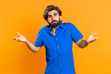 What Why. Sincere irritated man raising hands in indignant expression, ask reason of failure demonstrating disbelief irritation by trouble. Handsome confused middle eastern guy on orange background - obrazy, fototapety, plakaty