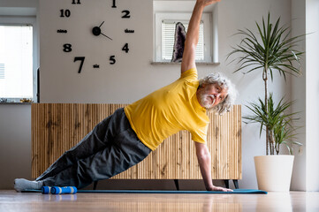 Active senior man in yellow tshirt taking care of his health by exercising - 645517979