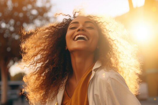 Portrait of beautiful african american woman smiling and looking away. Outdoor portrait of a black lady. Happy cheerful girl with curly black hair laughing