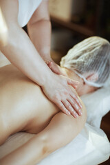Massage therapist in spa salon massaging clients back