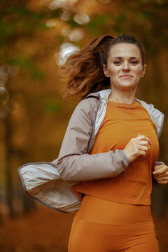 fit woman in fitness clothes in park running