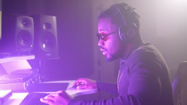 professional black sound engineer working in modern audio recording studio