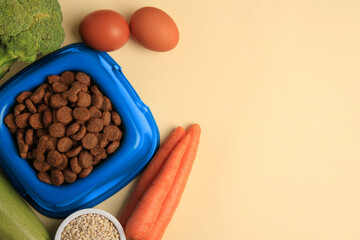 Dry pet food and products on beige background, flat lay. Space for text