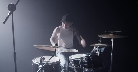 Talented male musician playing drums on stage