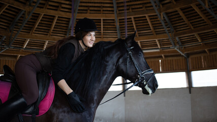 Equestrian sports. A young woman in the saddle, a rider and her horse in the arena, dressage horse
