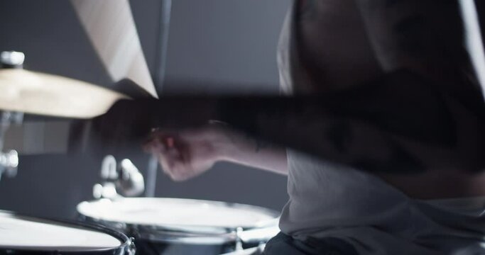 Man in cap playing beat on drum set on stage