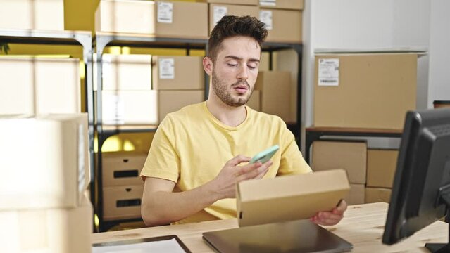 Young hispanic man ecommerce business worker scanning packages at office