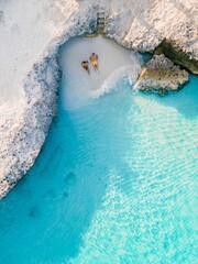 a couple of men and women on the beach of Tres Trap Aruba Caribbean Island. Tres Trapi Bay is...