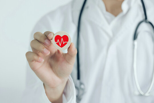 Doctor holding dice cube with heart rate icon. The concept for charity, health insurance, love, support, International Cardiology Day.World Heart Day.World Health Day.