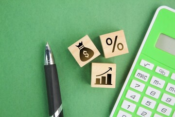calculator, pen and wooden cube with percent, money, profit icons. business management concept....