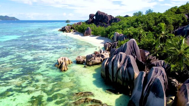 Anse Source d'Argent, La Digue Seychelles, tropical beach during a luxury vacation in Seychelles. Mature couple of men and women walking on the beach on a sunny day during holiday