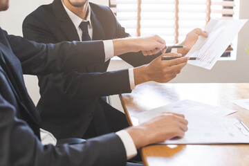 Business meeting, two caucasian, asian group man use pen, brainstorm analyzing on graph data of cost plan or document, paperwork and discussing in board room on table. People working conference room.