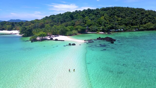 A couple of men and women on a tropical island in Thailand, Koh Kham Island Trat Koh Mak. tropical beach with white sand and blue ocean, men and women at a tropical sandbank