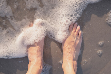 Female feet in the water of the northern sea