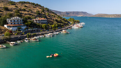 Fototapeta na wymiar panoramic view of the sea bay with boats and ancient buildings on the island of Crete filmed from a drone