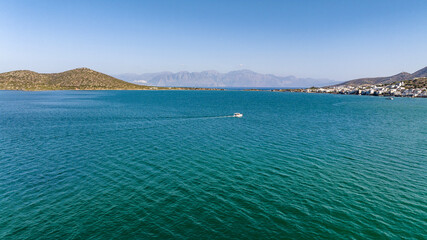 panoramic view of the sea bay with boats and ancient buildings on the island of Crete filmed from a drone