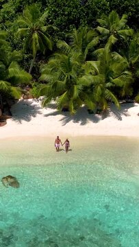 Anse Lazio Praslin Seychelles, a young couple of men and women on a tropical beach during a luxury vacation in Seychelles. Tropical beach Anse Lazio Praslin Seychelles Islands
