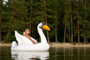 Outdoor recreation with family, child playing with inflatable swan.
