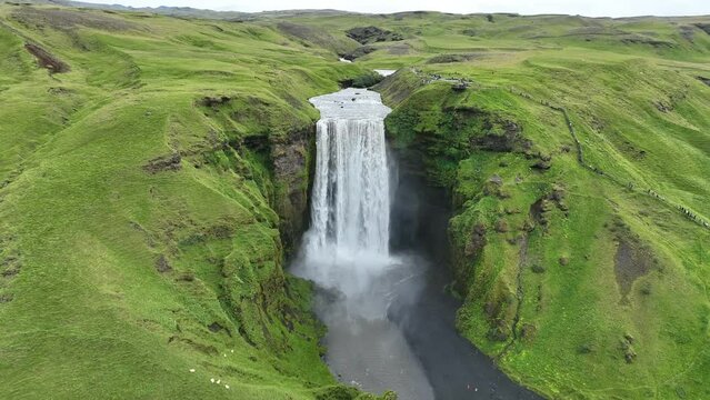 Skogafoss waterfall in the mountains in iceland. Aerial view Sk&oacute;gafoss is one of Iceland's biggest and most beautiful waterfalls with an astounding width of 25 meters and a drop of 60 meters 