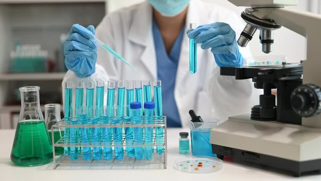 Scientists conducting research investigations in a medical laboratory, a researcher in the foreground is using a microscope in laboratory for medicine.  .