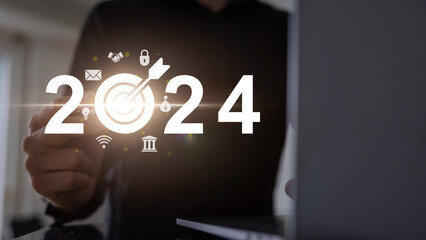 Businessman with target icon in hand on virtual screen. Startup business 2024. Merry Christmas and happy new year concept. 