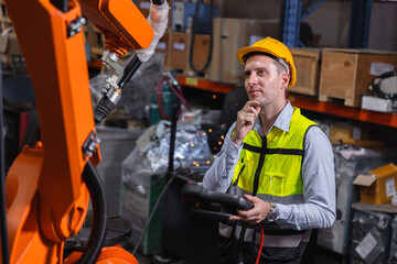 Engineer caucasion male working service fix operate automatic robot welding arm with question...