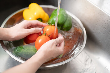 people washing raw vegetables at sink in the kitchen prepare ingredient for cooking - obrazy, fototapety, plakaty