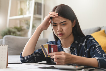 young asian woman cover her face after stressed with monthly bill expenses and credit card debt.