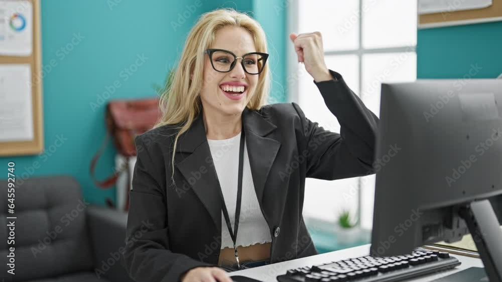 Wall mural Young blonde woman business worker using computer celebrating at the office