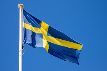 Flag scandinavia waving of the Sweden against blue sky in fabric blue yellow cross colors