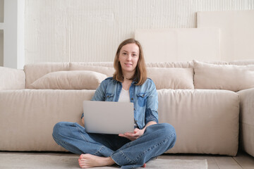 Nice beautiful lady work at the laptop sitting on the sofa at home. technology woman concept for alternative office freelance. Distance home office